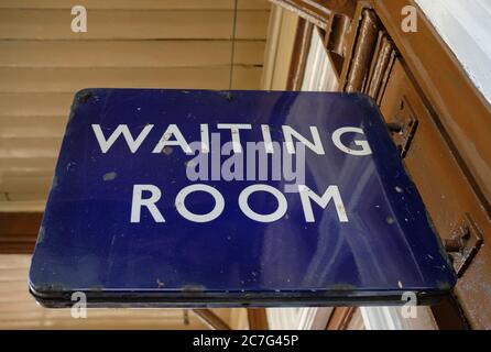 Close-up view of an old metal British Railway waiting room sign seen within a station platform area of a now disused railway station. Stock Photo