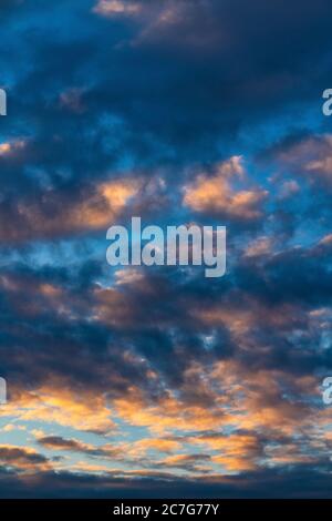 Beautiful clouds in blue sky, illuminated by rays of sun at colorful sunset to change weather. Soft focus, motion blur abstract meteorology background Stock Photo