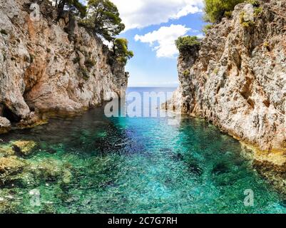 Clear turquoise sea water in the Amarandos Cove on the island of Skopelos is a reminder of a refreshing holiday in the Mediterranean summer. Stock Photo