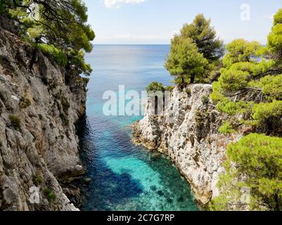 Clear turquoise sea water in the Amarandos Cove on the island of Skopelos is a reminder of a refreshing holiday in the Mediterranean summer. Stock Photo