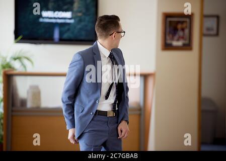 Shallow focus shot of a white male wearing a suit and tie attire looking back in a room Stock Photo