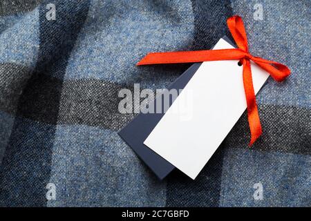 Clothing tag, label blank mockup on a clothes, to place your design.  fashion, people and shopping concept - close up price tag of clothing item Stock Photo