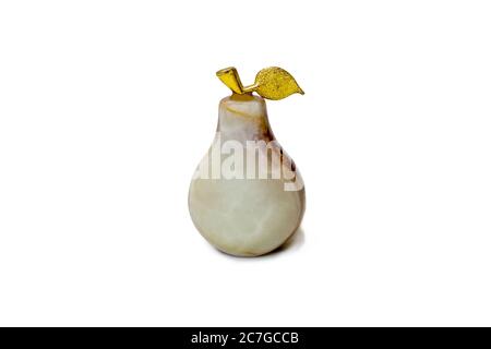 Decorative pear made of natural stone with a gilded twig on a white background close-up Stock Photo