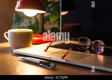 Glasses on laptop, freelancer workplace Stock Photo