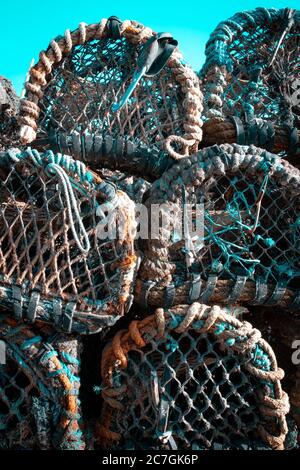 Fishing pots or traps stacked on a dock or quay Stock Photo