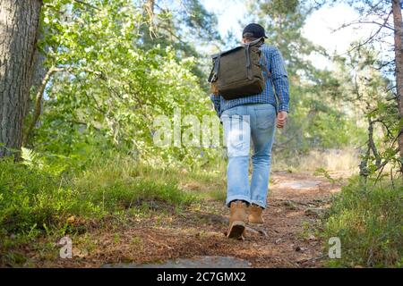 Man walking on a path through the forest Stock Photo