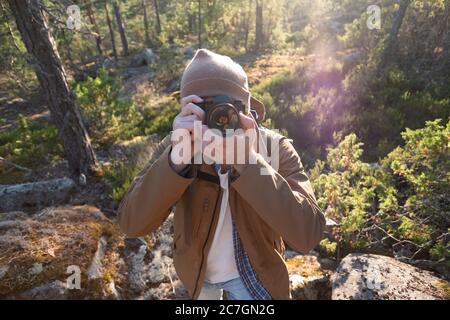 Male tourist using digital camera outdoors in a forest