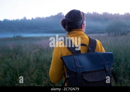 Caucasian woman walking through the meadow at the morning Stock Photo