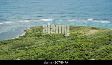 View over coastal road with native plants and Caribbean Sea from the Goat Hill hike on the East End of St. Croix in the US Virgin Islands Stock Photo