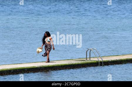 A woman enjoys the warm weather by the beach in Margate, Kent, as parts of the UK enjoy warm weather. Stock Photo