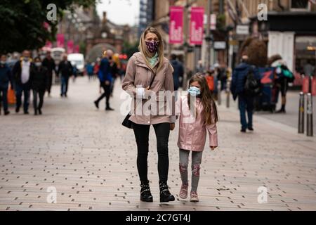 Glasgow, Scotland, UK. 17 July, 2020.  Images from Glasgow city centre as covid-19 restrictions are relaxed and  the public are out and about shopping and at work. Pictured; Mother and daughter walking on Buchanan Street wearing face coverings. Iain Masterton/Alamy Live News