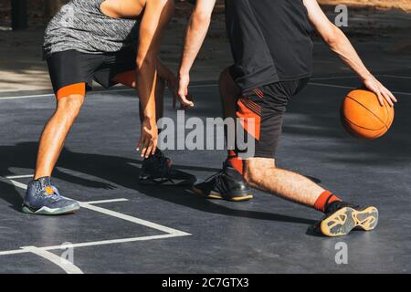 two unrecognizable people fight for the ball playing basketball Stock Photo
