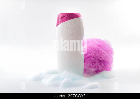 Personal hygiene, daily routine and body care toiletries concept theme with a bottle of shower gel soaked in water drops, bubbles made by soap foam an Stock Photo