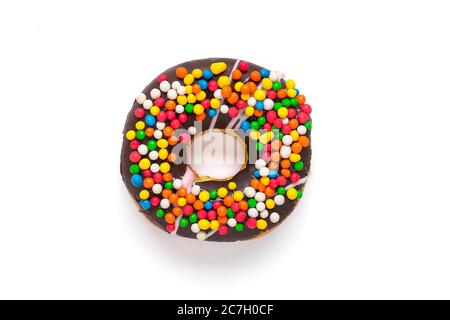 Classic chocolate donut decorated with colorful sprinkles isolated on white background Flat lat lay Top View Knolling Unhealthy and tasty food concept Stock Photo