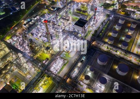 Aerial view oil and gas industrial, Refinery factory oil storage tank and pipeline steel at night Stock Photo