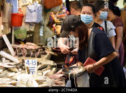 Hong Kong, China. 11th July, 2020. People buy sea food at a market in Hong Kong, south China, July 11, 2020. Hong Kong witnessed a resurgence of COVID-19 cases over the past weeks, prompting the government to step up preventive and control efforts again, including mandatory mask-wearing on public transport and closures of some entertainment venues. Credit: Lo Ping Fai/Xinhua/Alamy Live News Stock Photo