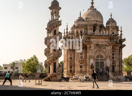 Junagadh, Gujarat, India - December 2018: People play cricket beside the ancient mausoleum of Mahabat Maqbara in the old city. Stock Photo