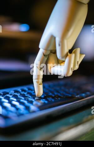 robotic hand typing on a computer keyboard Stock Photo