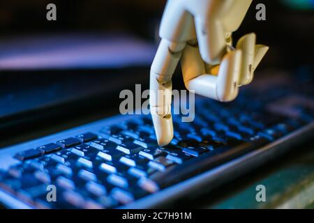 robotic hand typing on a computer keyboard Stock Photo