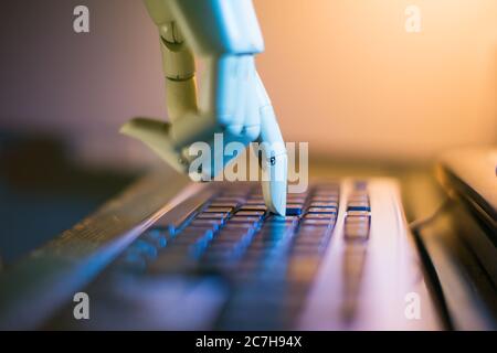 robotic hand typing on a computer keyboard Stock Photo