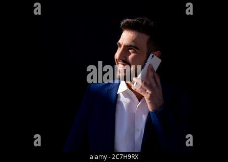 Portrait of a young executive with suit and cell phone Stock Photo