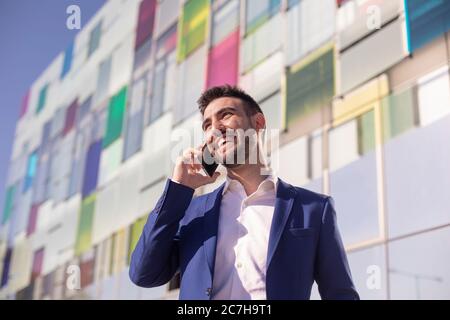 Portrait of a young executive with suit and cell phone Stock Photo