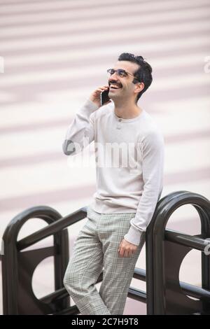 young smiling executive man next to offices talking on the phone Stock Photo