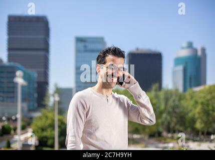 young smiling executive man next to offices talking on the phone Stock Photo