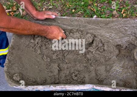 Master who works on plastering takes prepared mortar from hand carts. Stock Photo