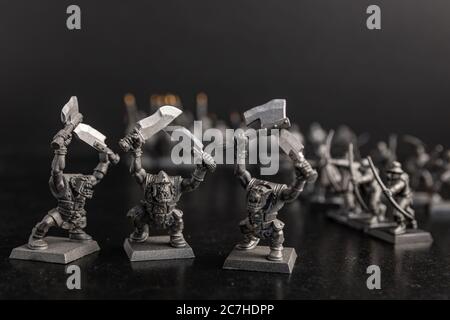 Grayscale selective focus shot of creatures holding swords figurines Stock Photo