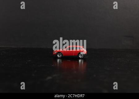 Selective focus shot of a red toy car on a black surface Stock Photo