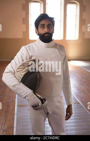 Portrait of man holding fencing foil and mask Stock Photo