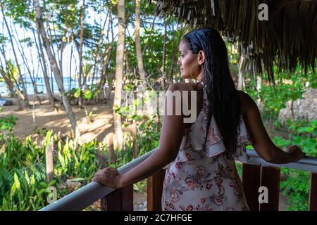 America, Caribbean, Greater Antilles, Dominican Republic, Cabarete, woman looks out from a balcony onto the beach at the Natura Cabana Boutique Hotel & Spa Stock Photo