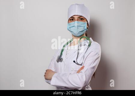 Portrait of a female doctor in a white medical uniform. Green stethoscope on the neck of a doctor. Stock Photo