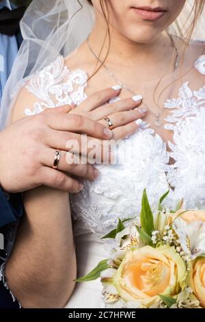 Gold rings in the hands of the bride and groom on the wedding day. Wedding and love Stock Photo