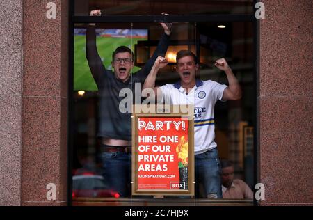 Leeds United fans celebrate in the Box bar in Leeds city centre as they watch Huddersfield Town take on West Bromwich Albion on Sky tv in a match that could seal their promotion to the Premier League. Stock Photo