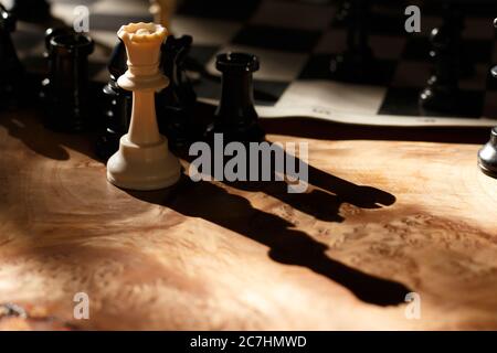 Wooden surface with black and white chess figures on a blurred background Stock Photo