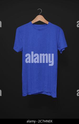 Dark blue T-Shirt on a hanger against a black background Stock Photo