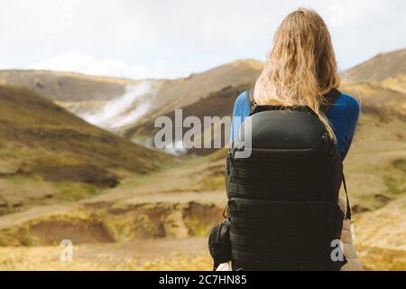 Female with hiking backpack looking at the beautiful mountains in Iceland Stock Photo