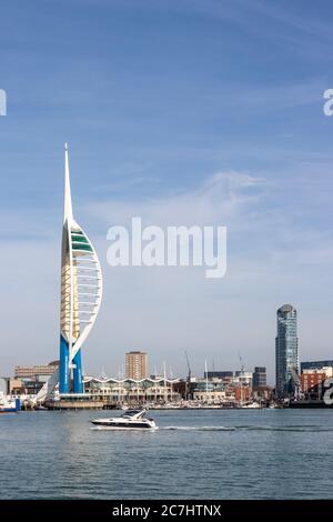 The spinnaker tower with a speedboat in the passing in the foreground and Gunwharf quays with the spinnaker tower in the background Stock Photo