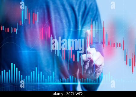 Businessman touching virtual screen with his finger - Technical price candlestick chart graph and indicator stock online trading Stock Photo