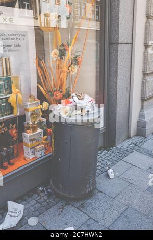An overflowing trash can in Munich city center. Disadvantages of fast food. Stock Photo