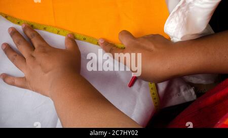 Tailor measuring garment on the table Stock Photo