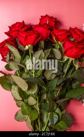 Gift or present box wrapped in kraft paper and roses on blue background. Flat lay styling. Copy space for text. Stock Photo