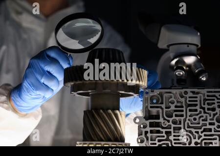 Man in lab examines parts of vehicle Stock Photo