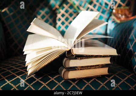 Vintage old books and book with open pages on the antique chair Stock Photo