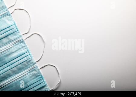 Several Medical Face Masks Pattern Resting on Gradated Surface. Stock Photo