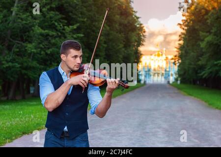 young man violinist in the public park playing the violin Stock Photo