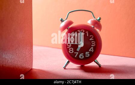 red analog alarm clock on red ground Stock Photo