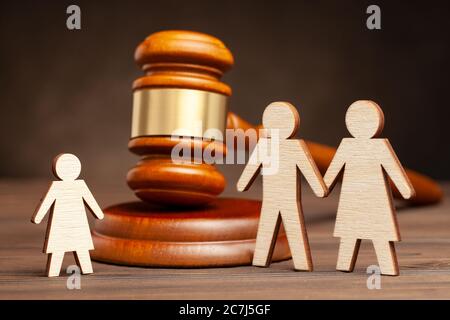 Deprivation of parental rights. The law protects children from parental violence. Mother and father apart from the child and judge's hammer. Stock Photo